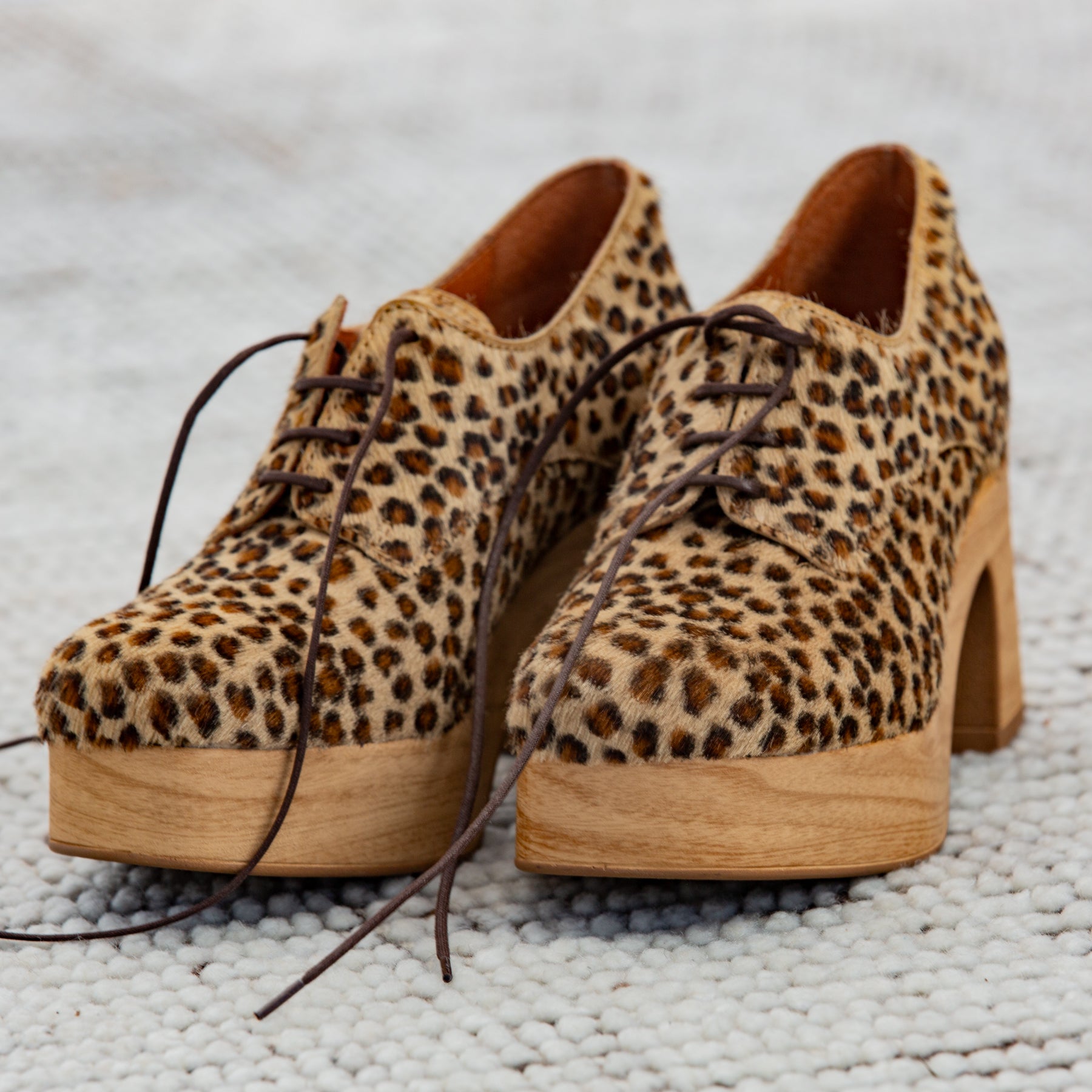 Leopard print platform shoes on a textured surface