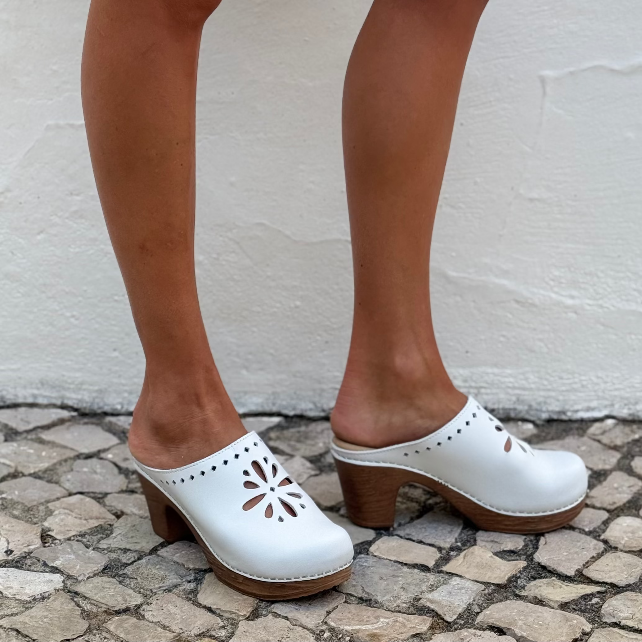 Lifestyle White wooden clog with flower cut-out and flexible sole by Calou