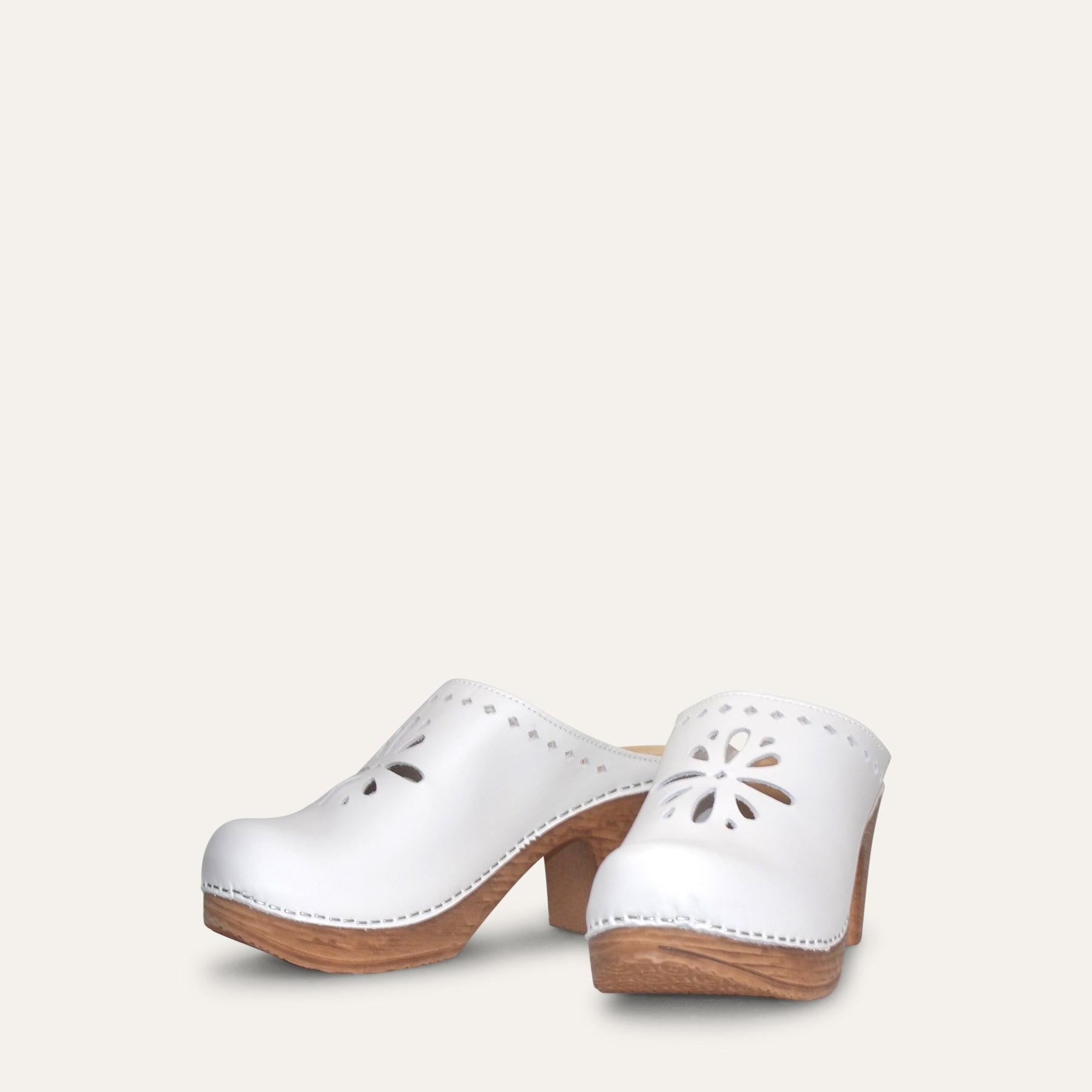 White clog with wood-look heel and flower cut out, flexible sole by Calou