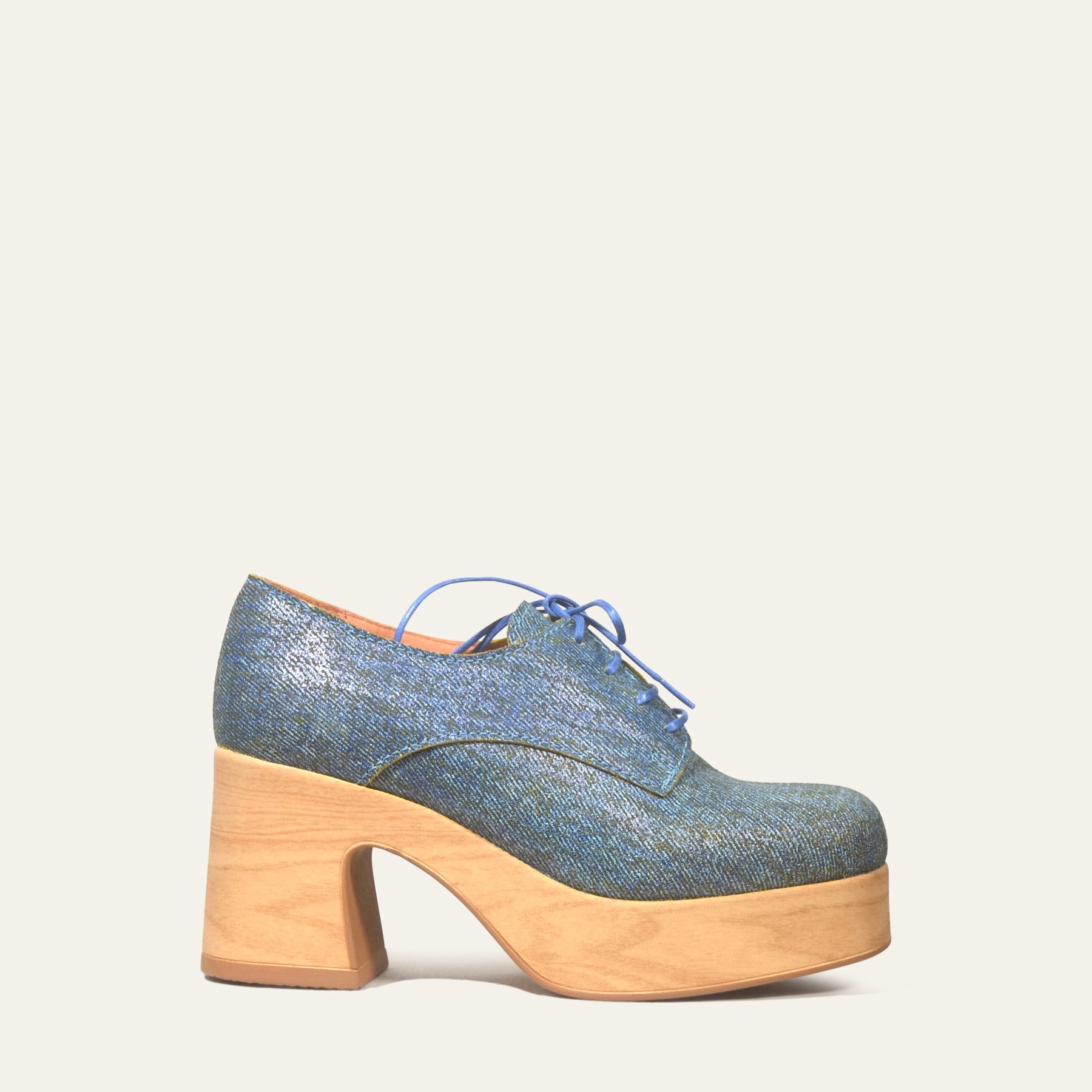 Blue denim shoe with wooden sole on a light gray background