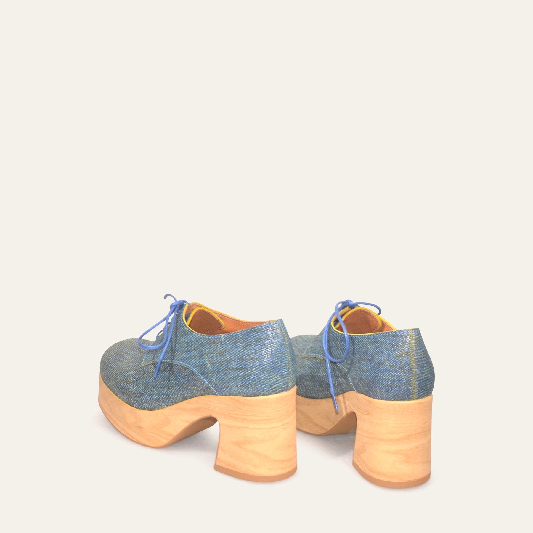 Pair of blue and beige platform shoes on a white background