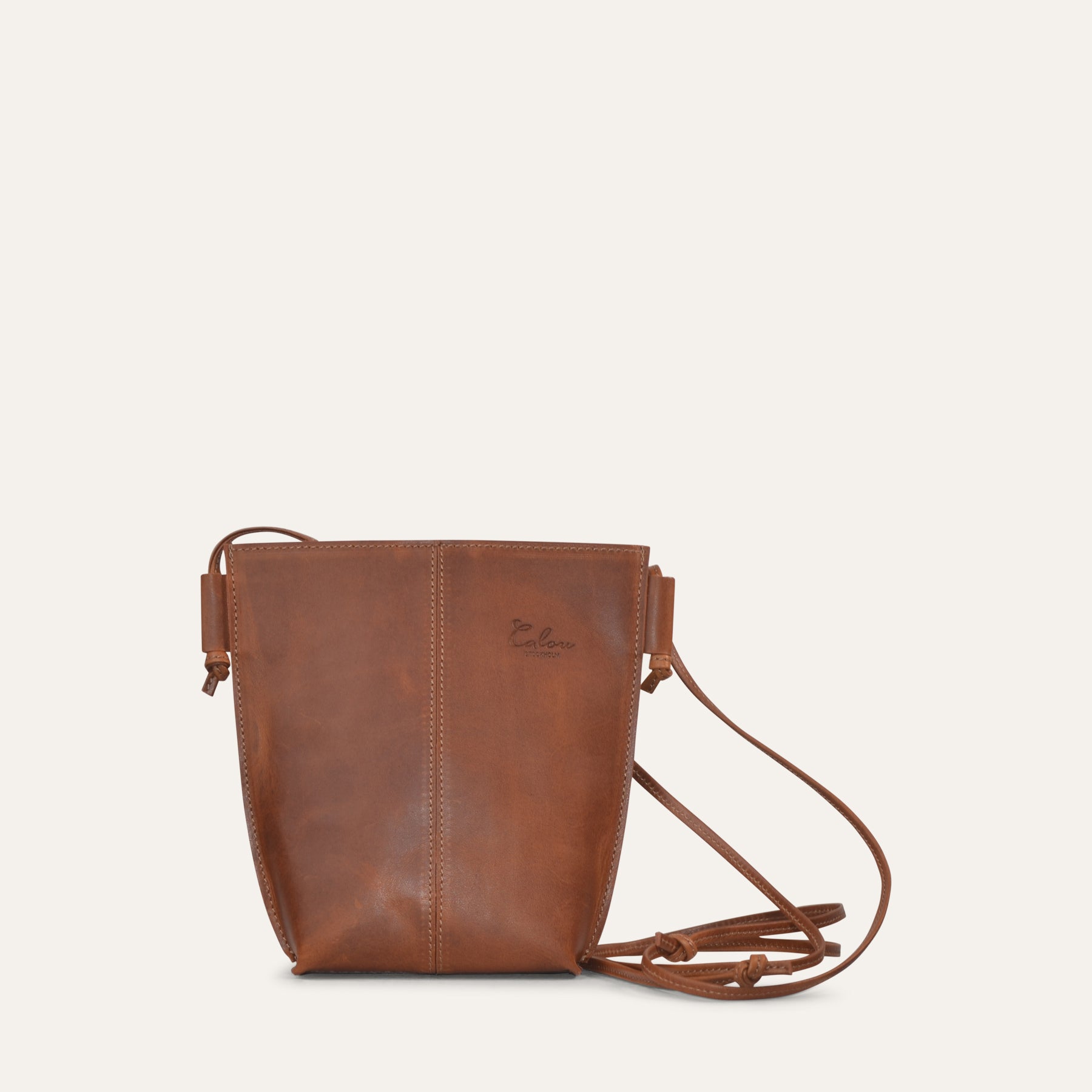 Brown leather crossbody bag on a light beige background