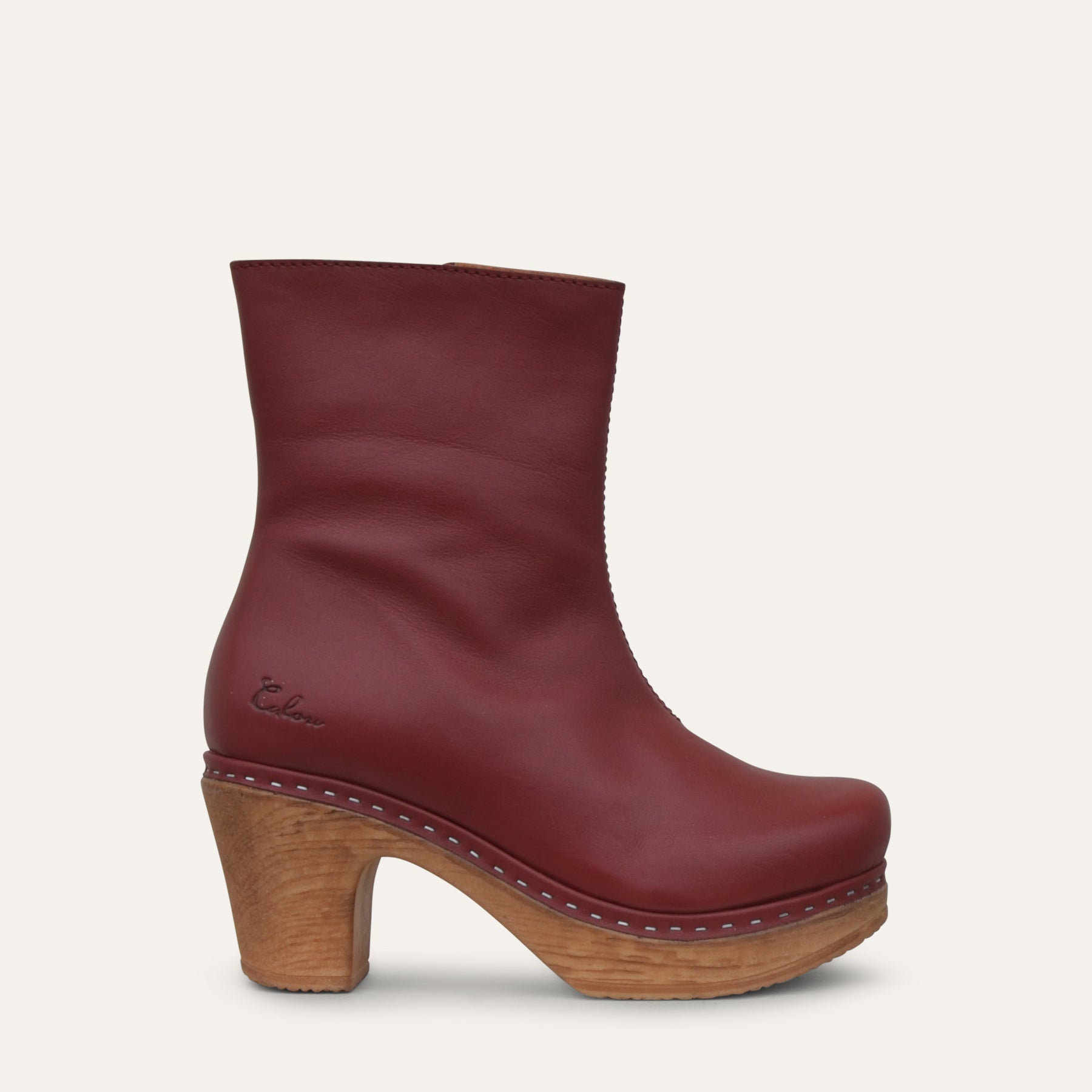 Bordeaux ankle boot with wood effect heel on a light gray background