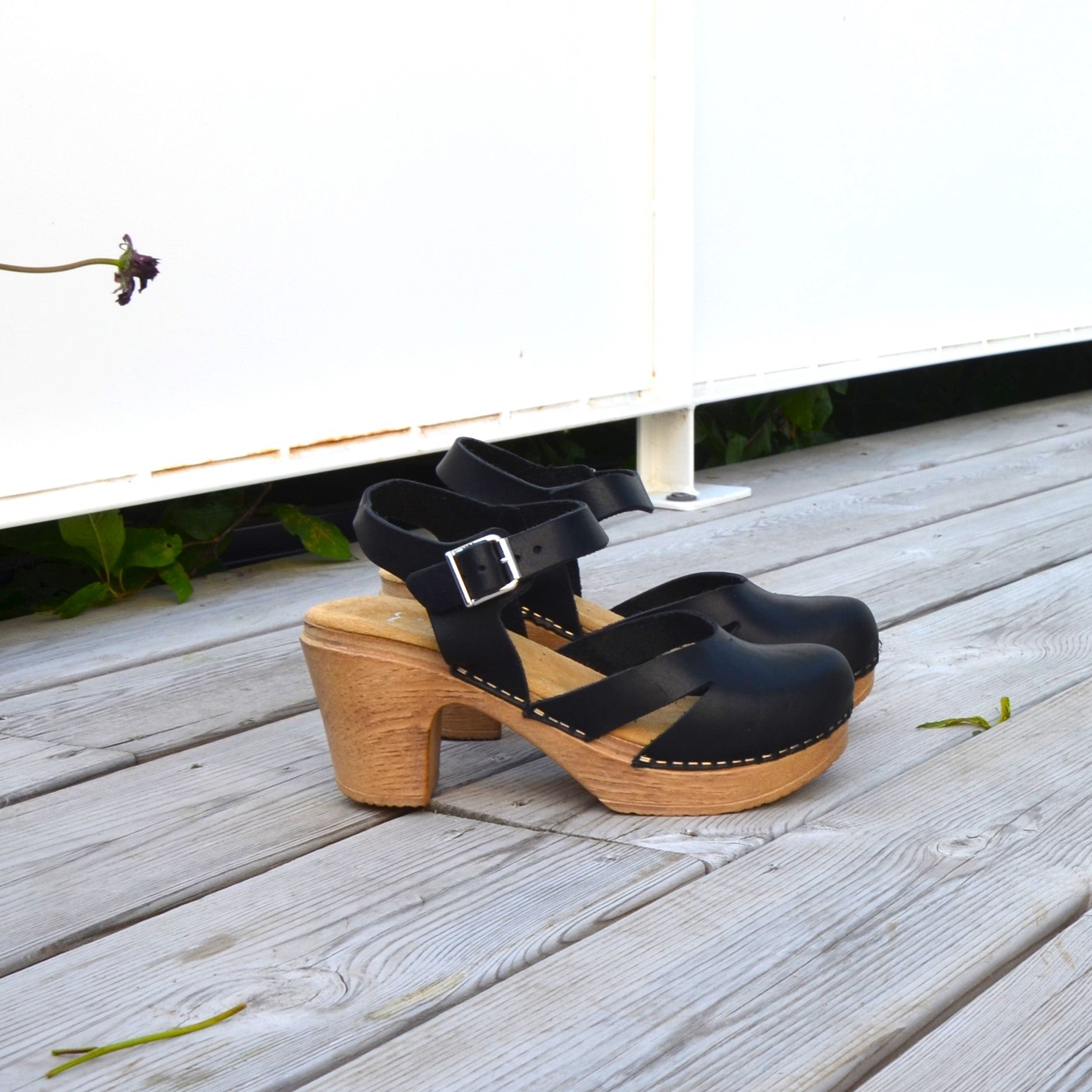 Penny black leather clogs on deck, Calou Stockholm