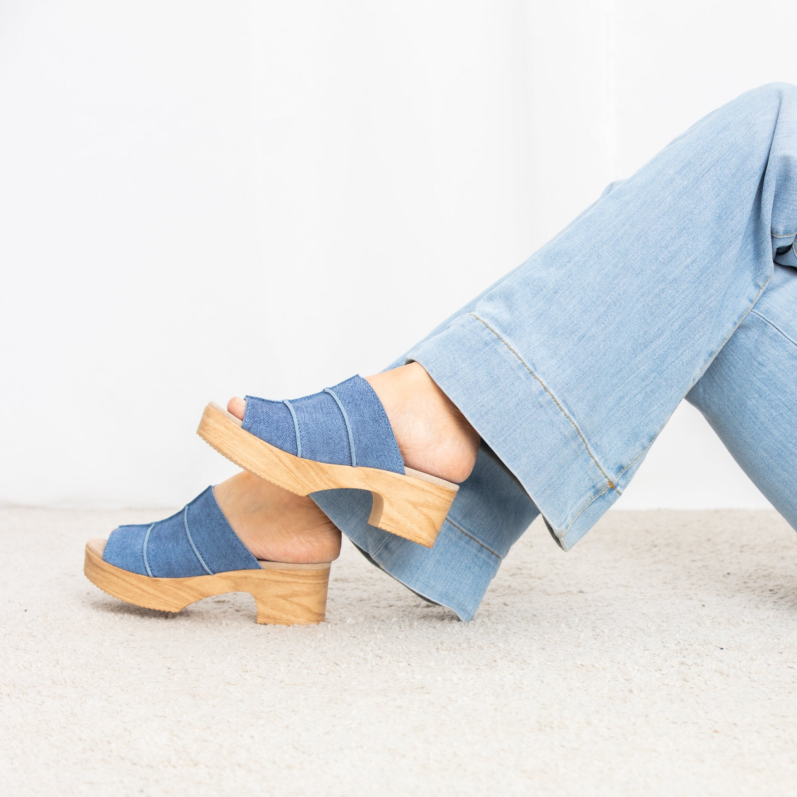 Tova blue suede clogs on model Calou